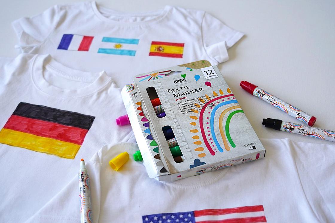 Mit Flaggen bemalte T-Shirts und das KREUL Textil Marker medium Junior 12er Set