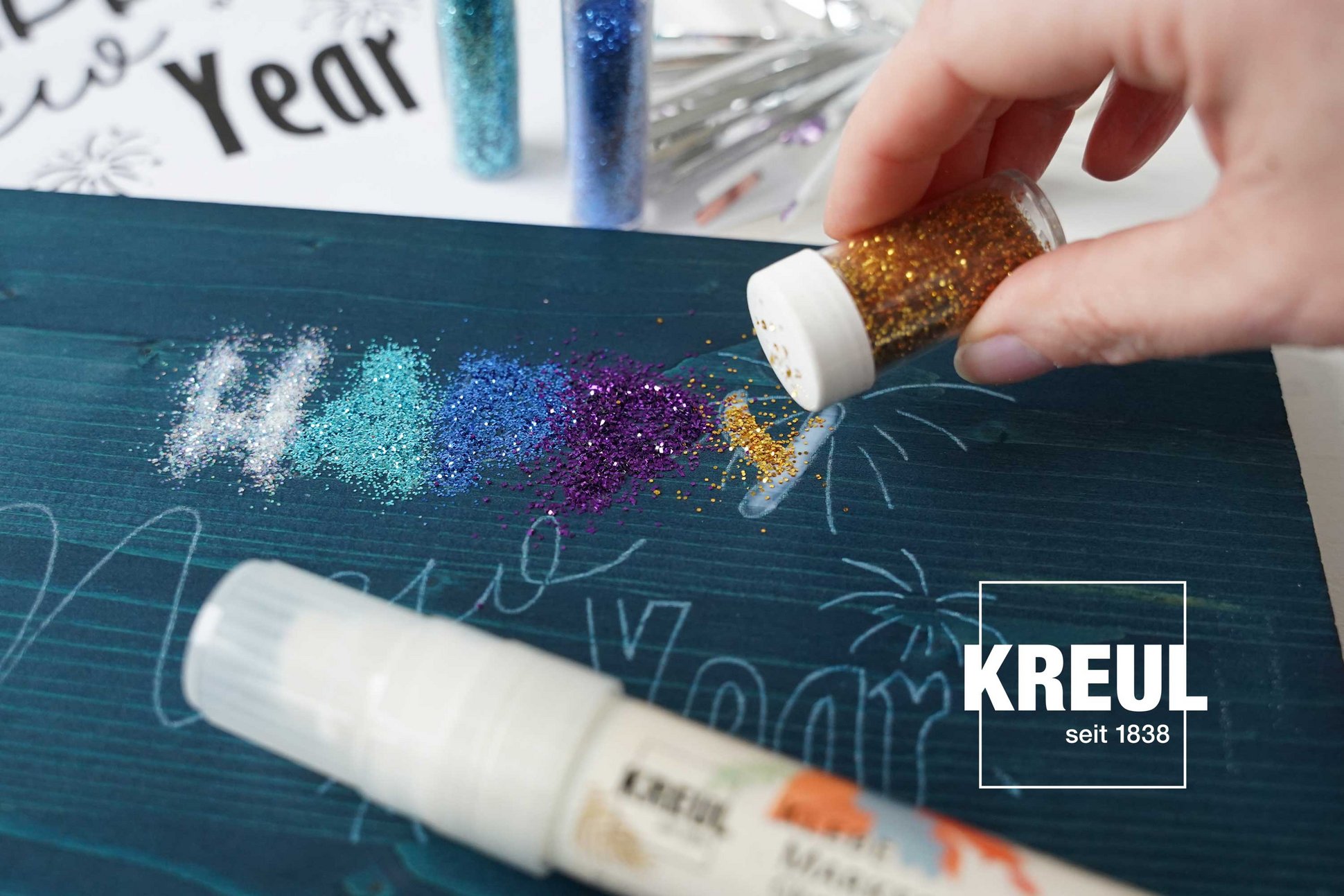 Glitzer Lettering Buchstaben Anleitung mit Kleber KREUL DIY Bastel Idee Sylvester Neues Jahr Glitzer Partikel auf Buchstaben mit Kleber streuen