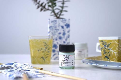 KREUL Glass & Porcelain Potch im Glas neben Tasse und Vase, die mit Serviettentechnik beklebt wurden