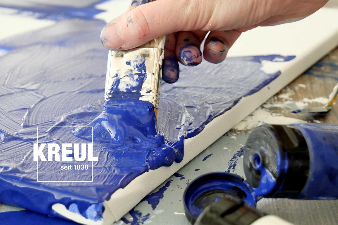 Malen mit blauer Acrylfarbe auf Leinwand