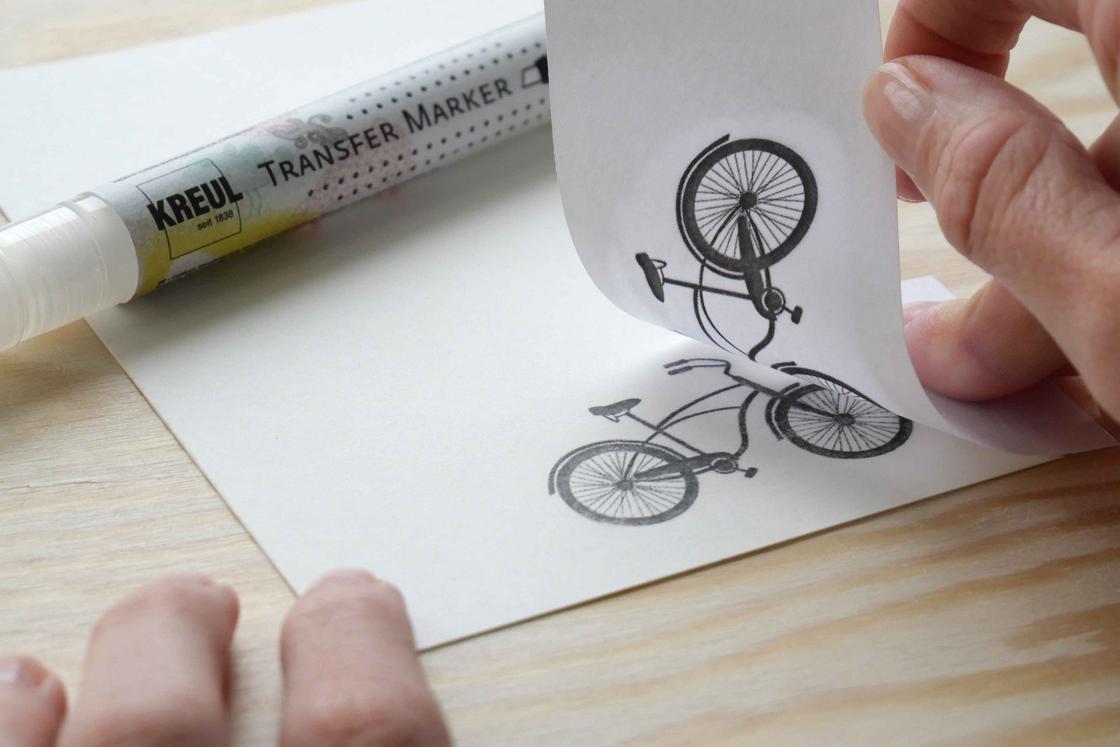 Fahrrad Motiv Design übertragen auf Papier Karton Stein Moosgummi Textilien Tutorial Fragen Antworten Anleitung Hand mit Postkarte auf die ein Fahrrad-Motiv mit Marker übertragen wird