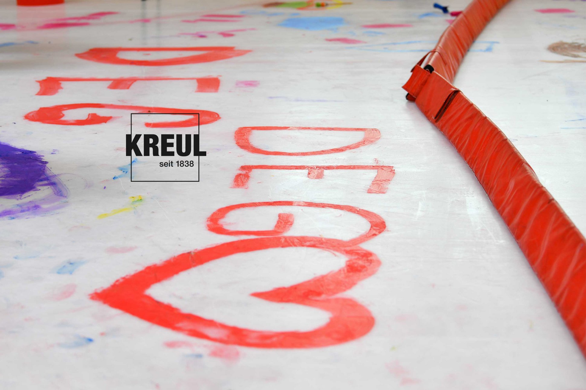 MUCKI Fingerfarbe beim DEG Eismalen Eishockey Event für Kinder Mit MUCKI Fingerfarbe auf Eisfläche Aufgemalter DEG-Schriftzug