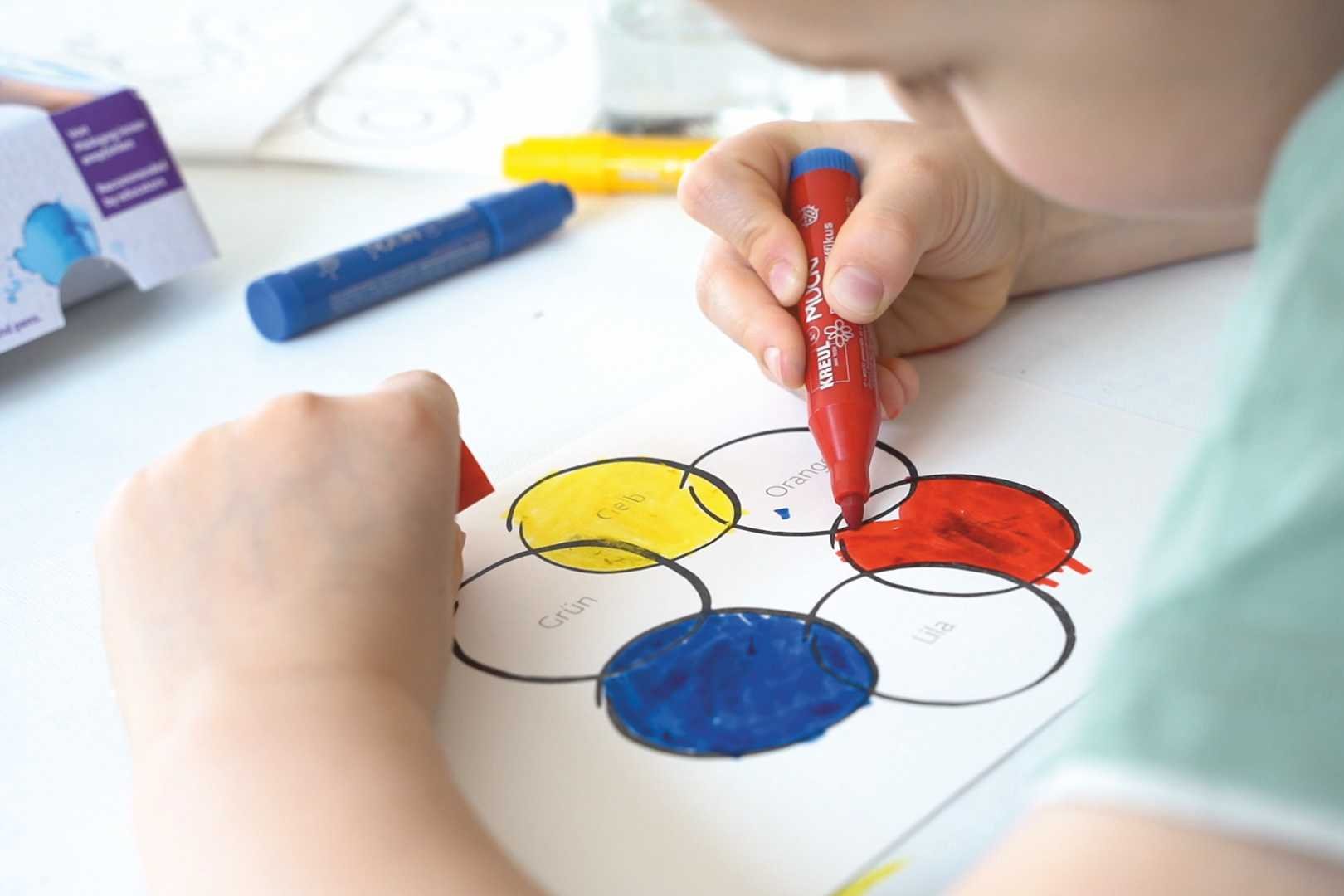 Kind malt Farbkreis mit rotem Stift