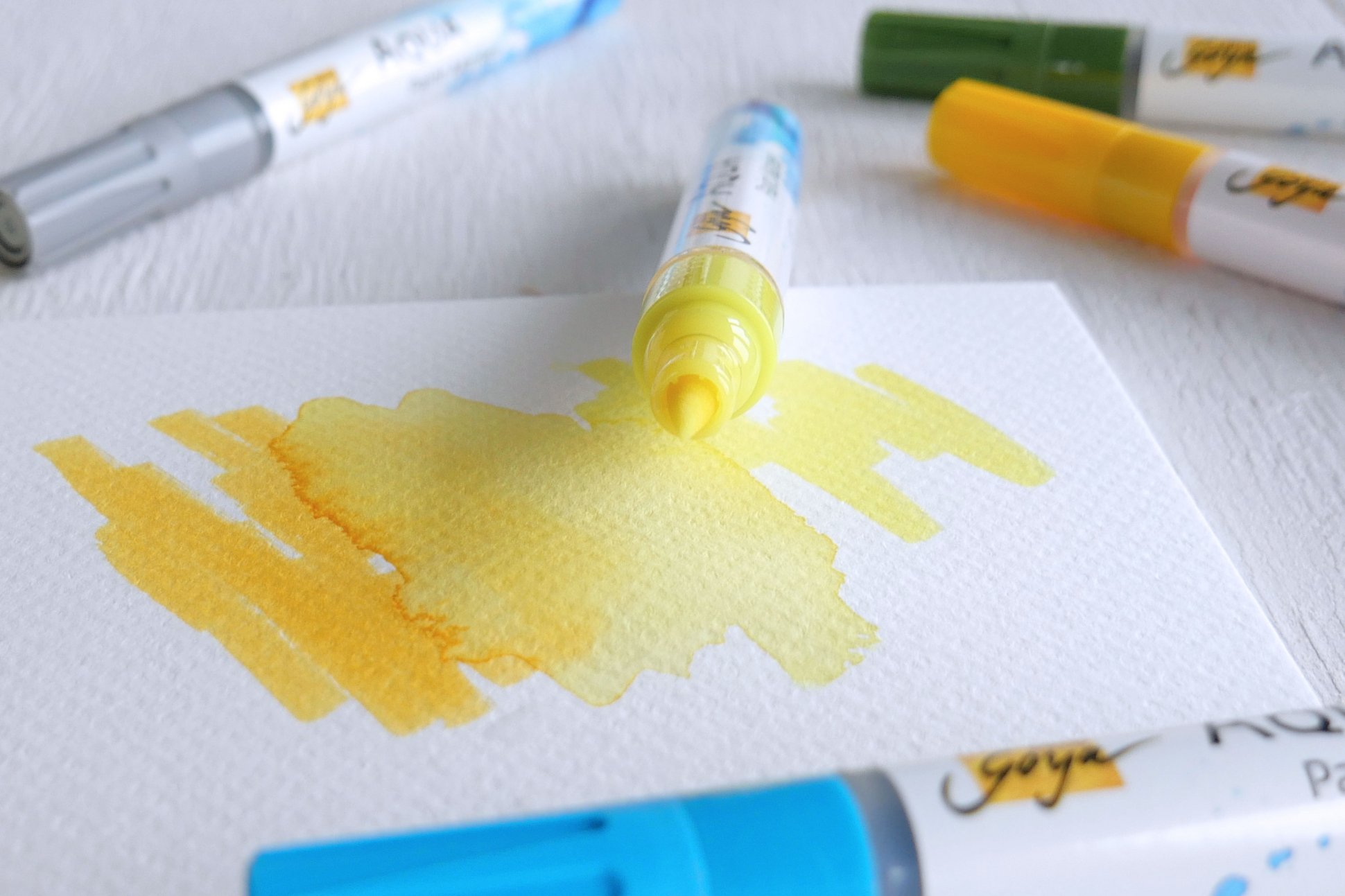 Gelber Stift auf gelbem Papier Künstlerstifte daneben