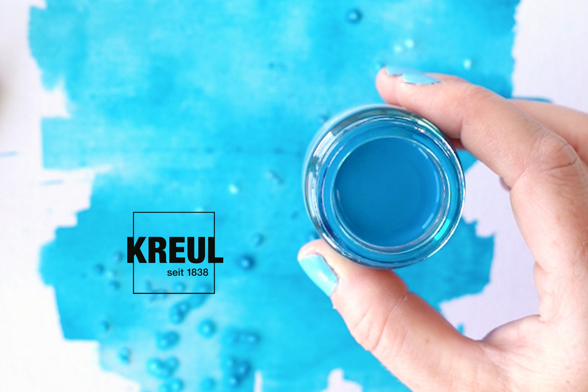 KREUL Seidenmalfarbe flüssig brillant lichtecht wasserfest zum Malen auf Papier Lettering Aquarell Stil Hand mit geöffnetem Glas KREUL Seidenmalfarbe in Türkis