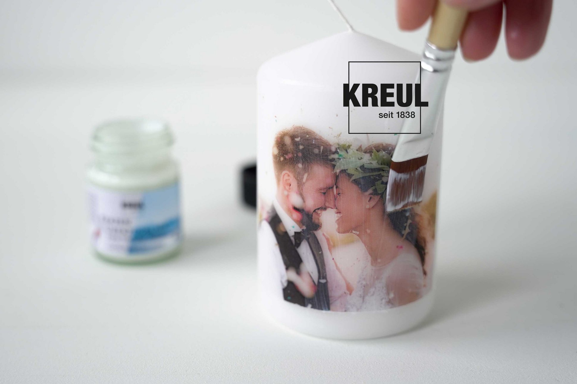 KREUL Foto Transfer Potch Kerzen Überzugslack Foto eines Hochzeitspaars auf einer Kerze, mit einem Pinsel wird ein Überzugslack aufgestrichen