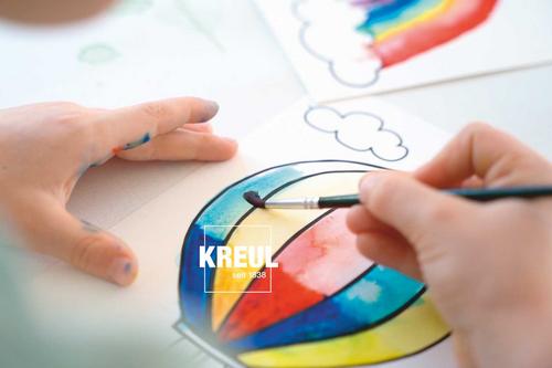 Kinderhand malt mit Pinsel einen Heißluftballon bunt aus