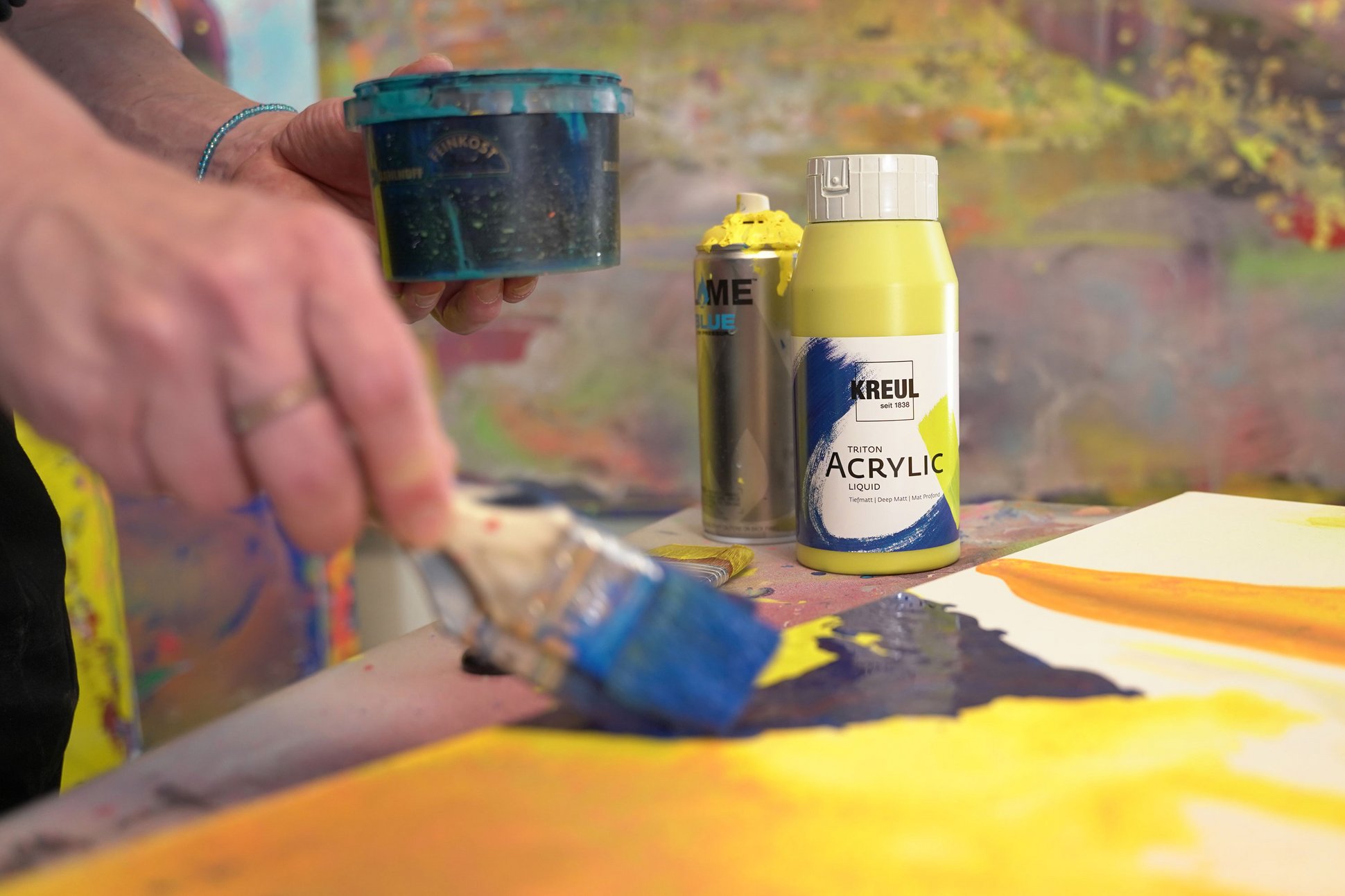 Auftrag von KREUL Triton Acrylic Liquid auf eine gelbe Leinwand