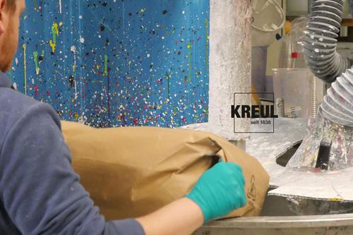 Mann bei der Farbenproduktion am Dispergierer mit Rohstoff-Sack