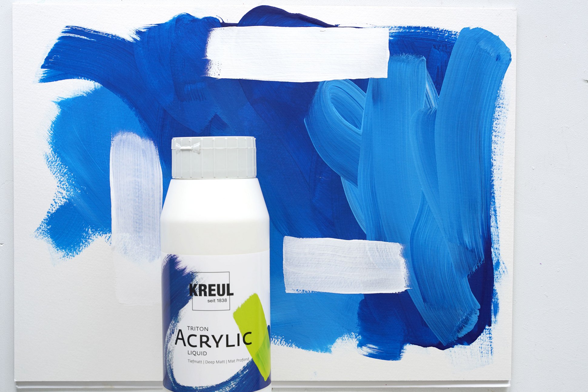 KREUL Triton Acrylic Liquid Titanweiß vor einer Leinwand mit Titanweiß und Weiß Farbaufstrich