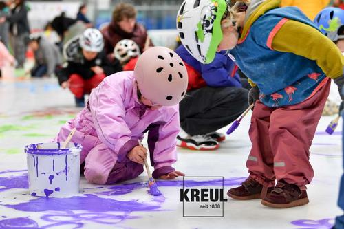 zwei Kinder beim DEG Eismalen mit lila Fingerfarbe und Pinsel