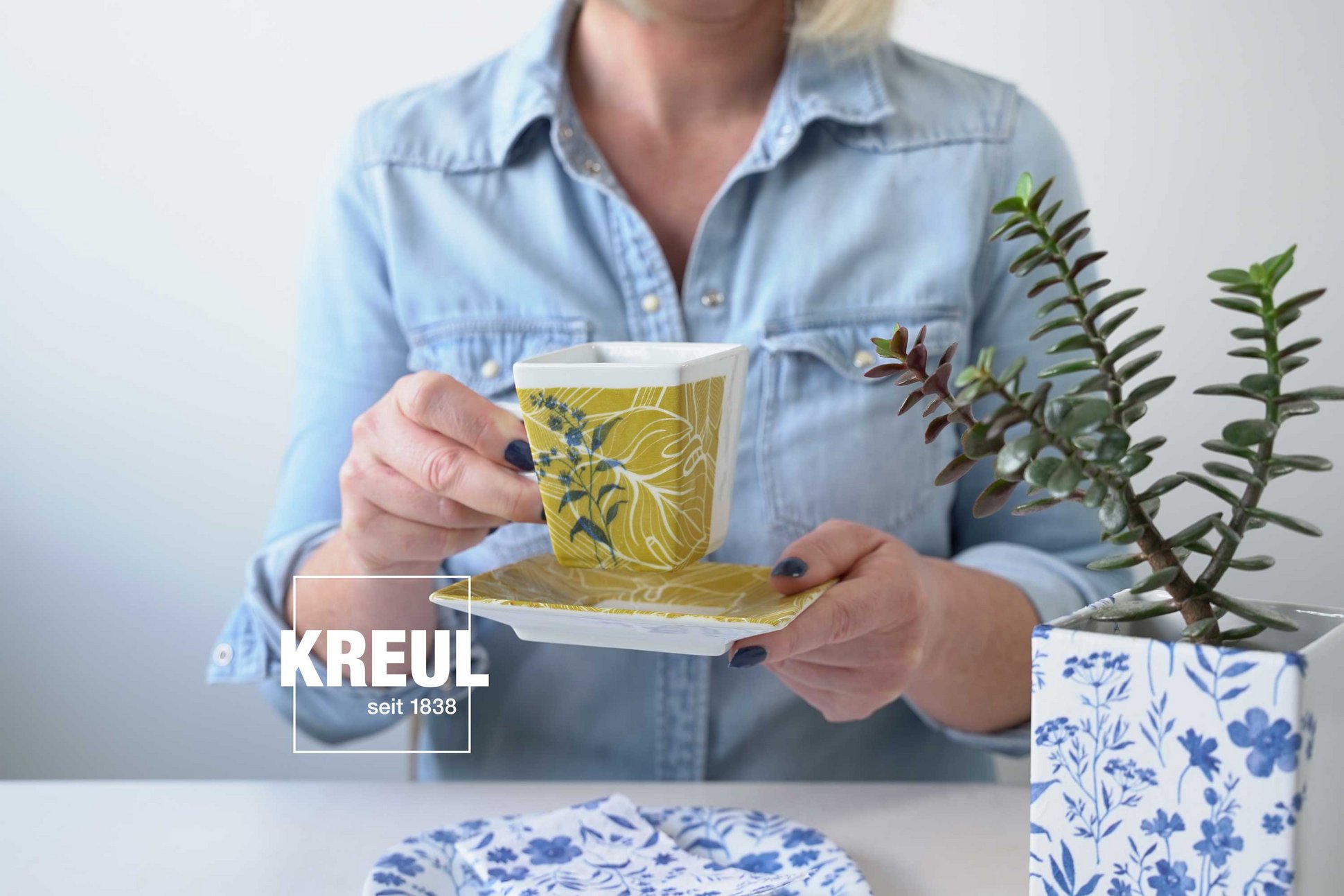 Frau mit selbst designter Tasse durch Serviettentechnik