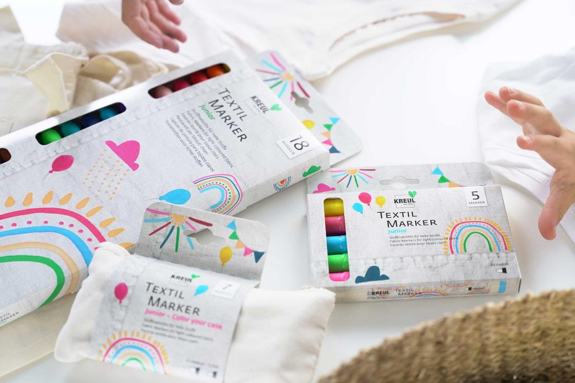 Kindergeburtstags Basteln Tool Stifte Stoff Textil Marker Idee Blitz Idee spontanes Basteln Aktion wenig Vorbereitung Textil Stifte für Kinder auf dem Tisch Hände greifen danach