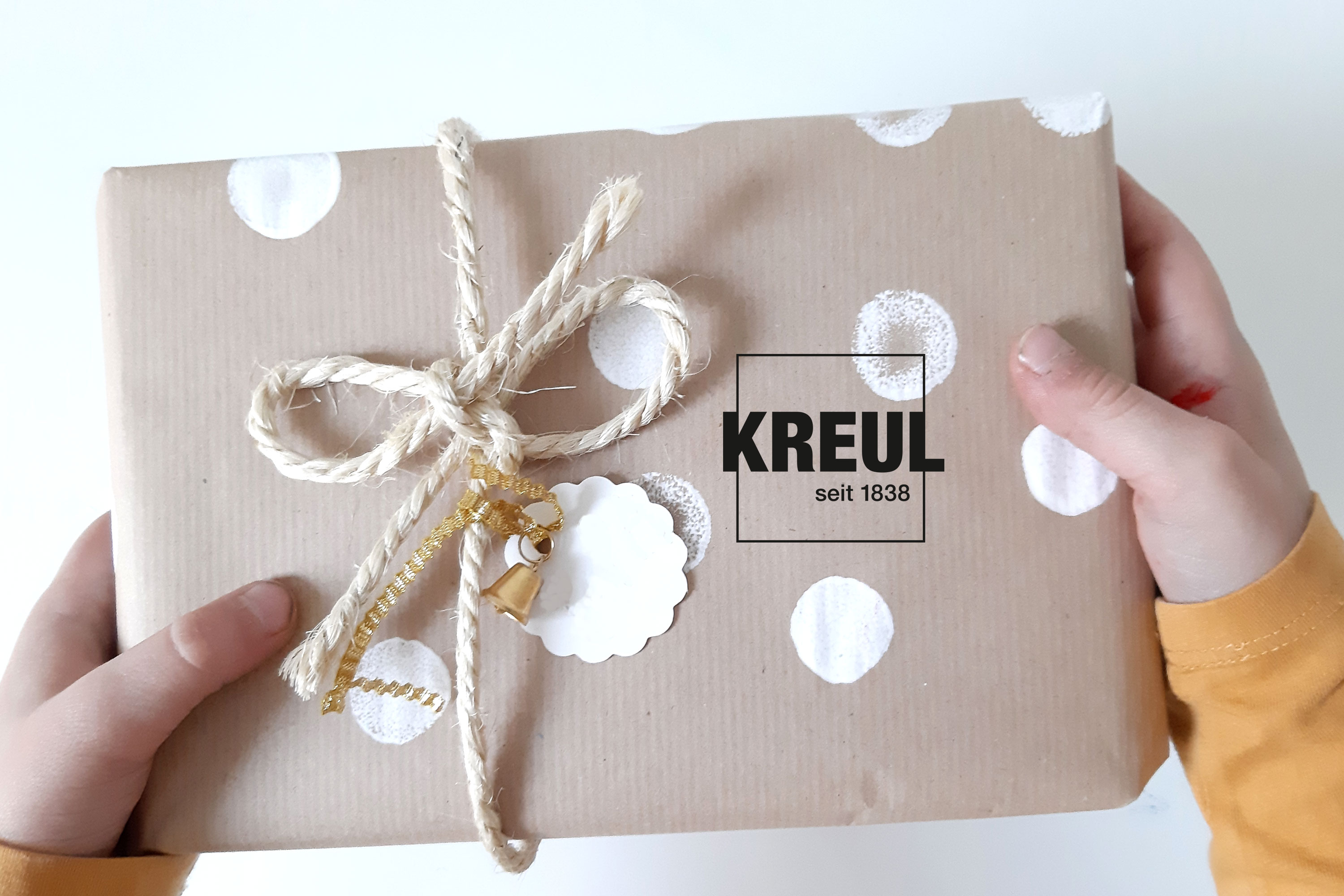Kinderhand überreicht verpacktes Geschenk