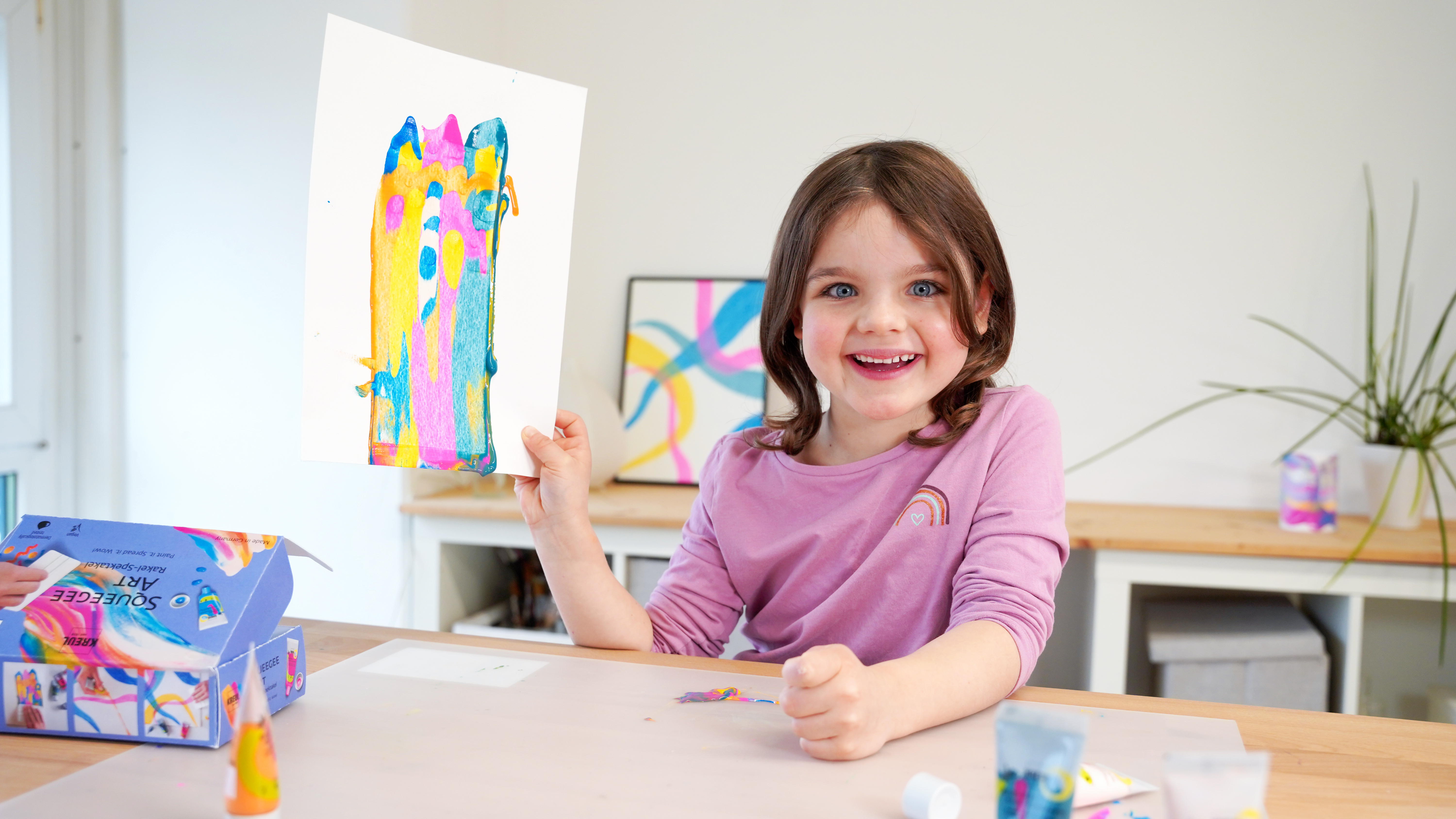 Mädchen mit abstraktem Wisch-Kunstwerk in der Hand